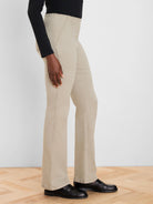 Khaki boot-cut jeans with a high waist and visible seams, worn by a model from the waist down.
