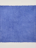 Cobalt blue cashmere neck scarf with a visible, loose weave texture and frayed edges.