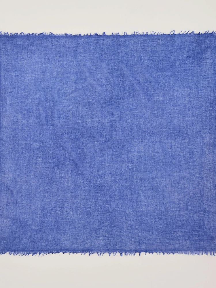 Cobalt blue cashmere neck scarf with a visible, loose weave texture and frayed edges.