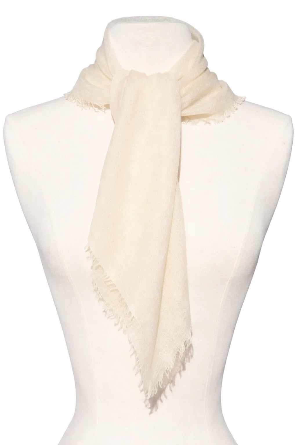 Cream scarf with frayed edges, tied on a mannequin.