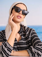 A light cream cashmere scarf, softly draped over a model's head, with fringed edges.
