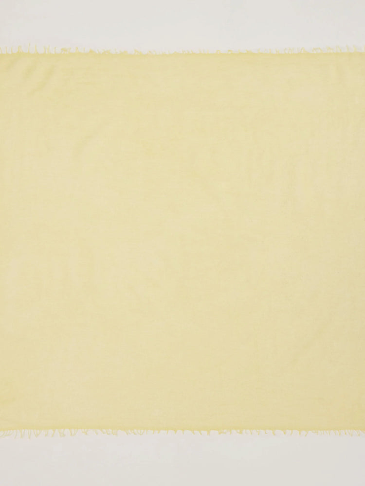Pale yellow scarf with smooth texture and short fringed edges.