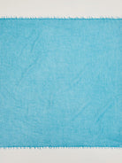 Bright turquoise cashmere neck scarf with a visible soft texture and fringed edges.