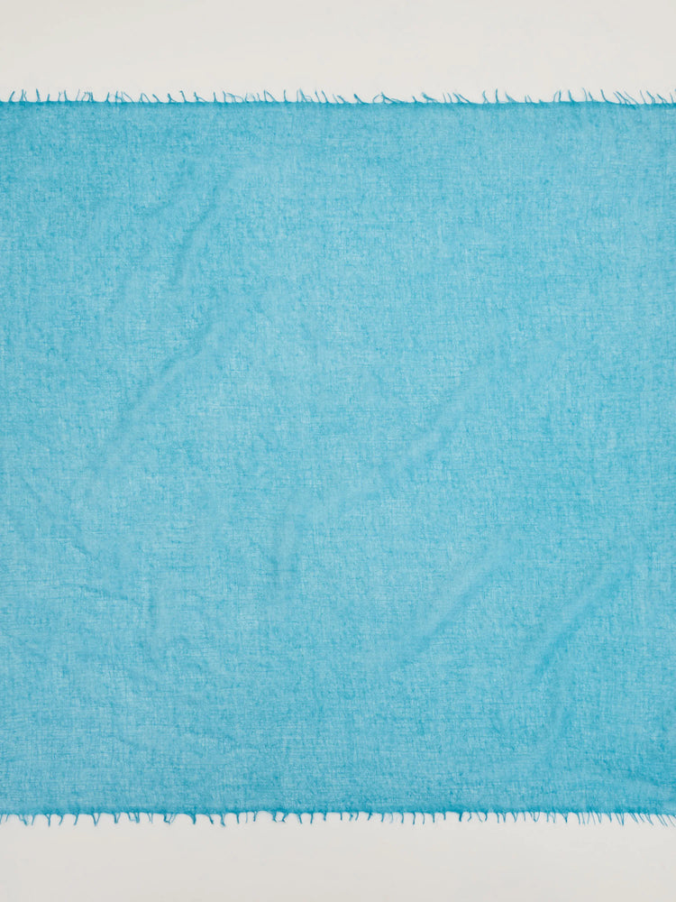 Bright turquoise cashmere neck scarf with a visible soft texture and fringed edges.