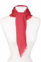 Muted red scarf with soft texture and fringed edges, tied around a mannequin's neck.