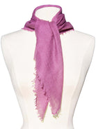Magenta cashmere neck scarf tied on a mannequin, showing its soft texture and frayed edges.