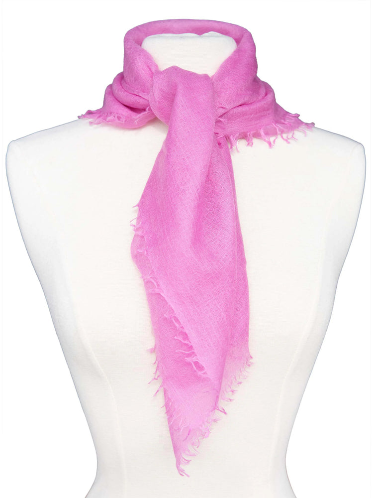 Fuchsia cashmere neck scarf, tied on a mannequin, with frayed edges.