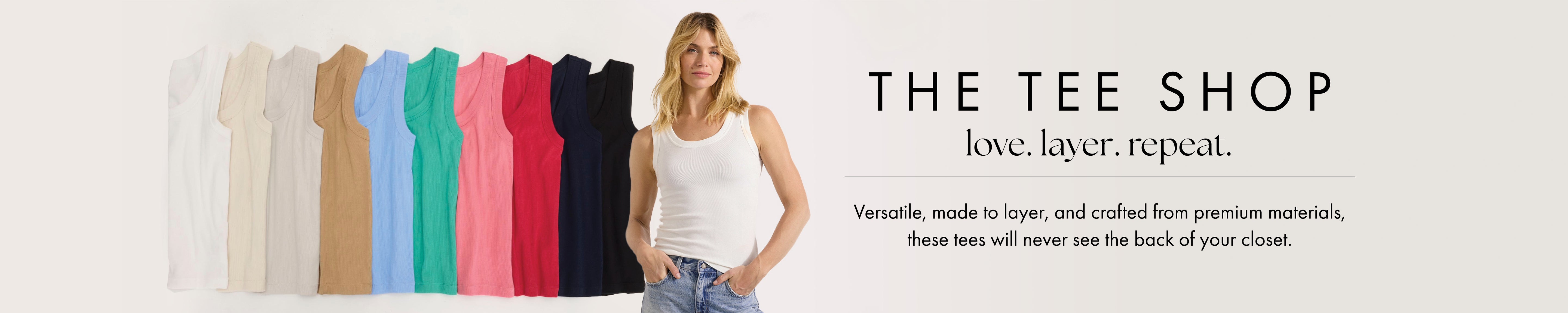 Woman standing next to a row of colorful t-shirts with 'The Tee Shop' branding.